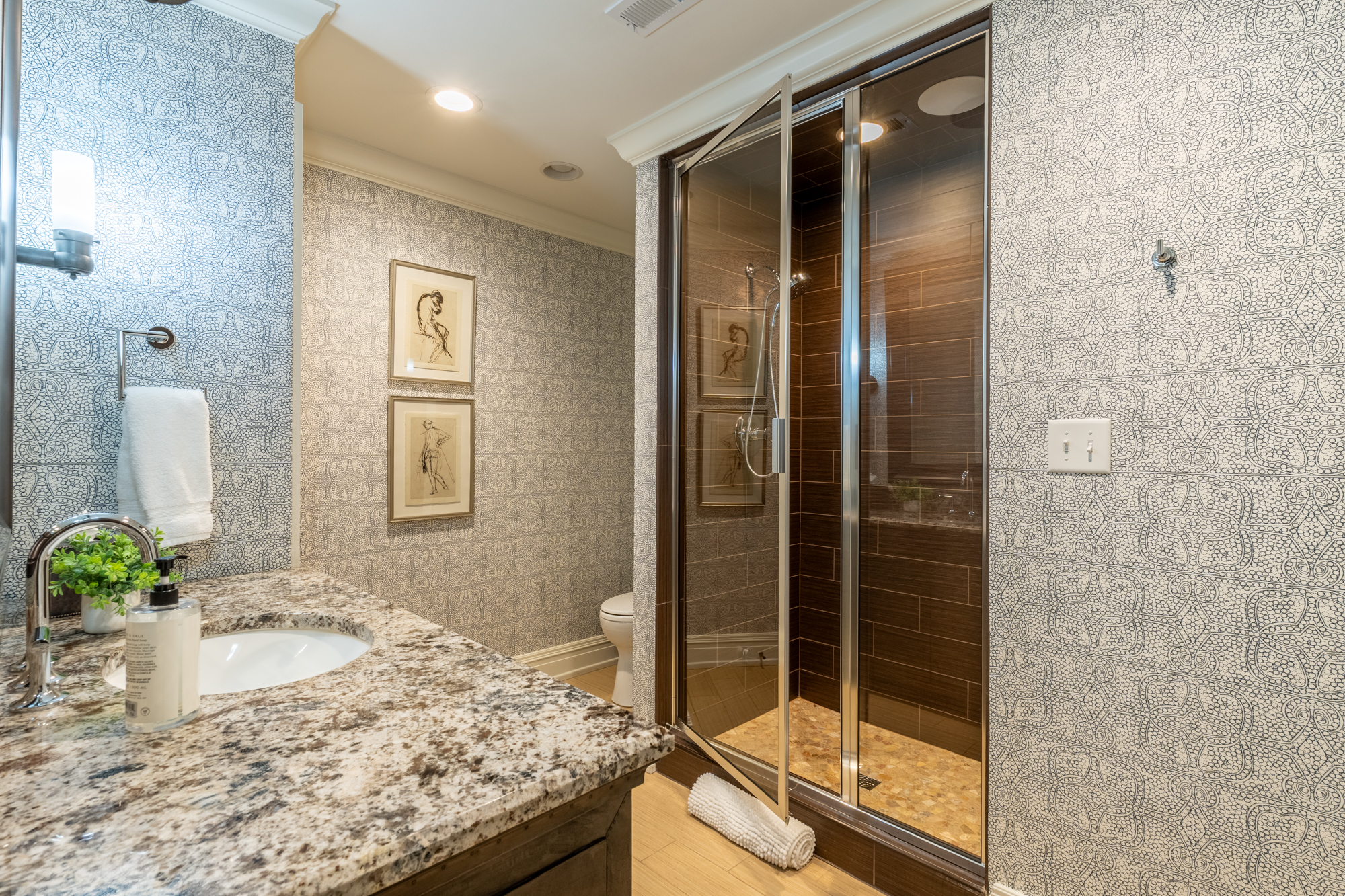 Bathroom with intricate patterned walls and a warm wood-tiled shower